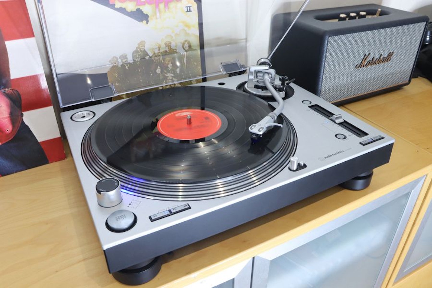Audio-Technica LP140XPSVEUK Professional Manual Turntable on a unit next to LPs and a Marshall speaker
