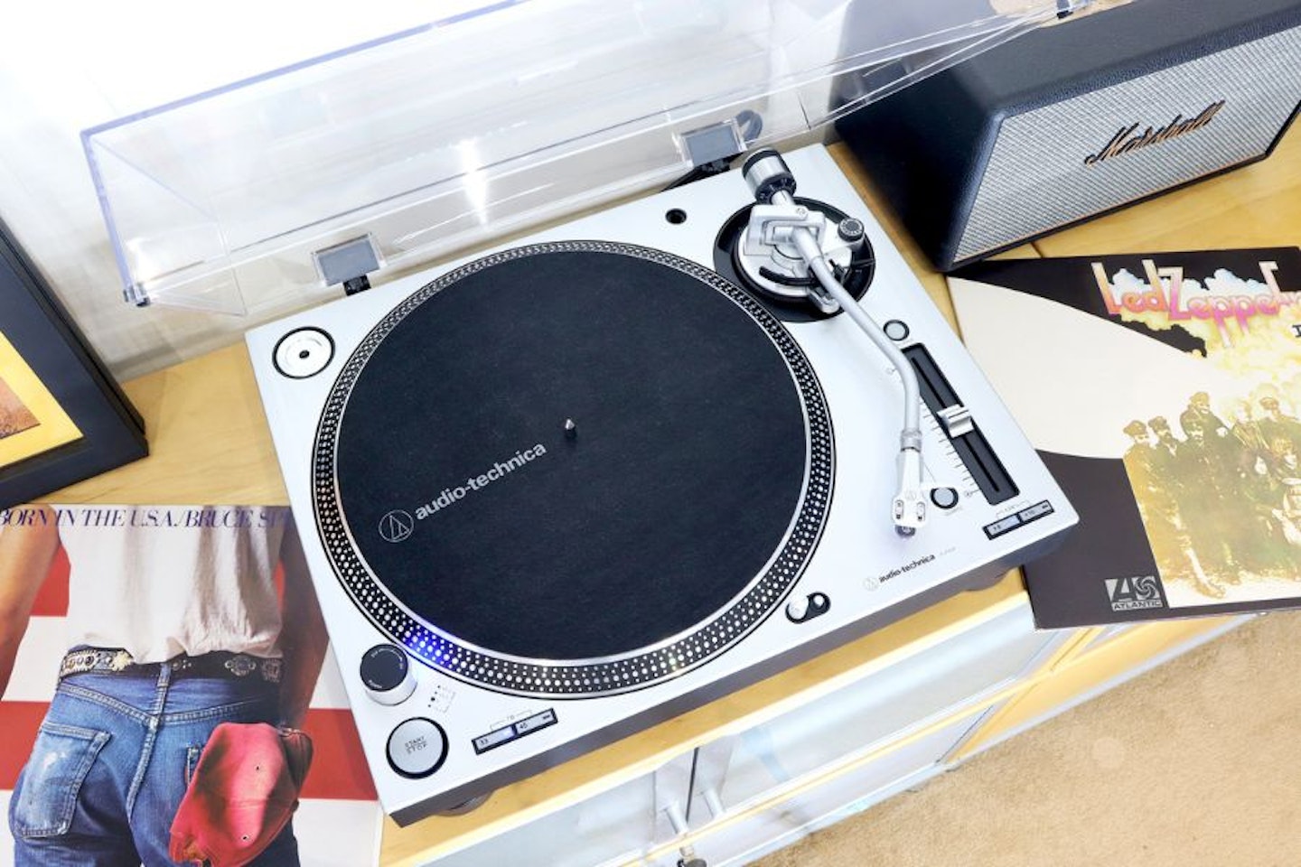 Audio-Technica LP140XPSVEUK Professional Manual Turntable on a unit next to LPs